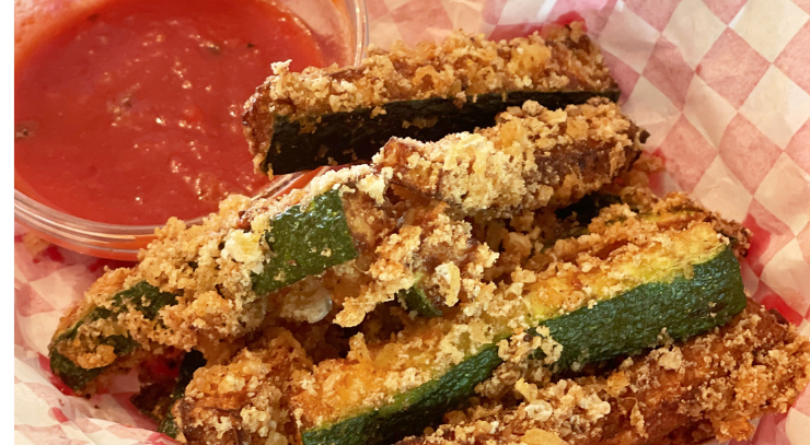 amazing crispy keto zucchini fries in a red basket with a small bowl of marinara sauce for the blog keto on the rise