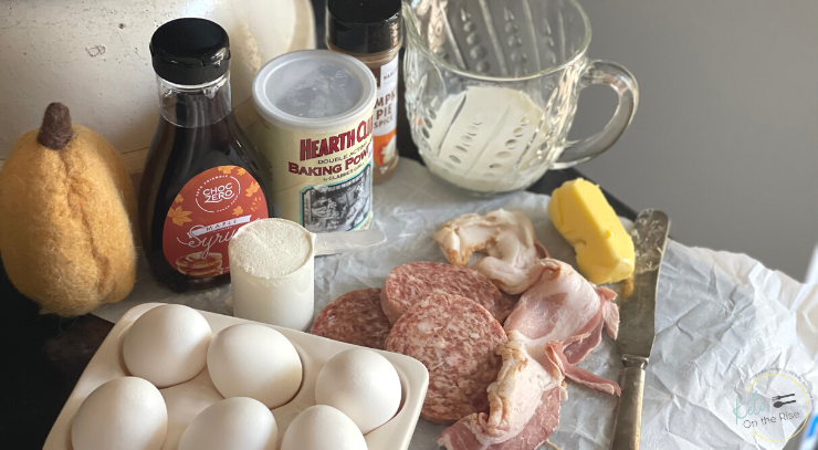 Picture of Eggs, bacon, sausage and the ingredients to make keto pancakes for the blog post cozy fall breakfast with keto pancakes and syrup for the blog keto on the rise