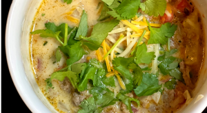 Creamy Keto Taco Soup in a white bowl topped with shredded cheese and fresh cilantro for the blog keto on the rise